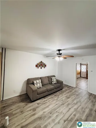 a living room with furniture and a wooden floor