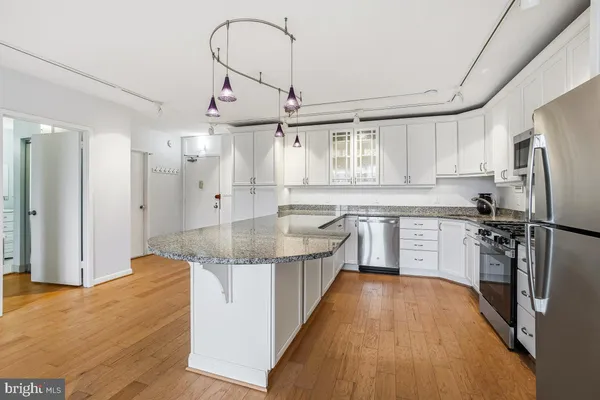 a kitchen with stainless steel appliances granite countertop a sink refrigerator and cabinets