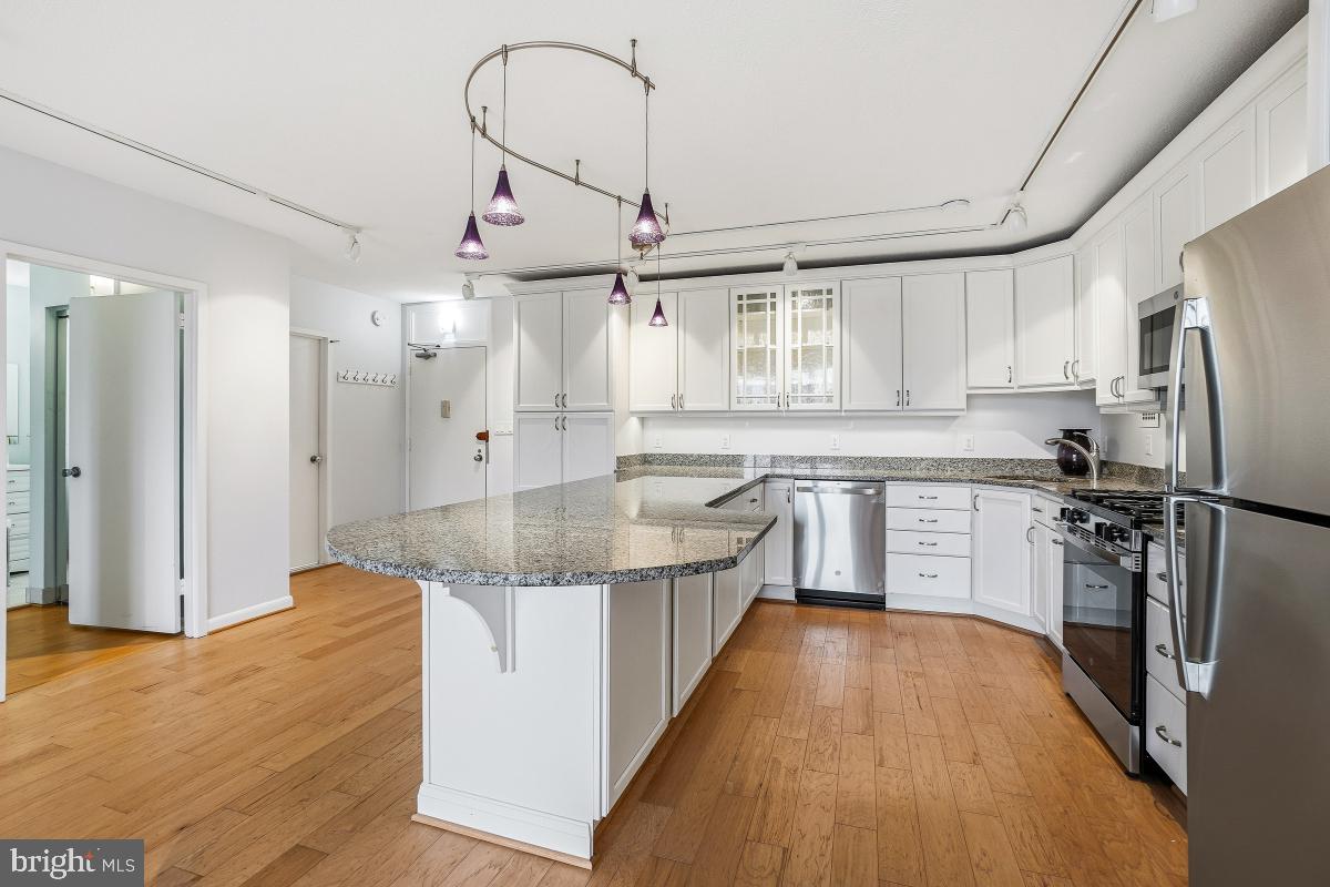 a kitchen with stainless steel appliances granite countertop a sink refrigerator and cabinets