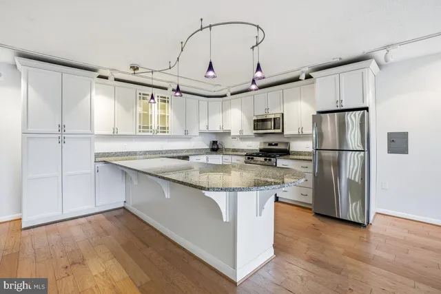a kitchen with stainless steel appliances granite countertop a sink a refrigerator and a stove