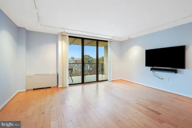 a view of room with wooden floor and flat screen tv
