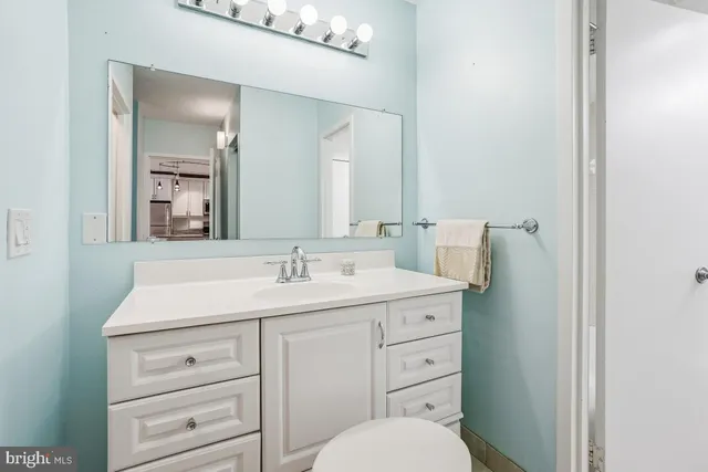 a bathroom with a toilet sink vanity and mirror