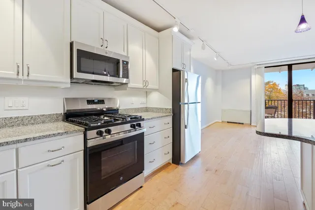 a kitchen with stainless steel appliances granite countertop a stove a refrigerator and a microwave