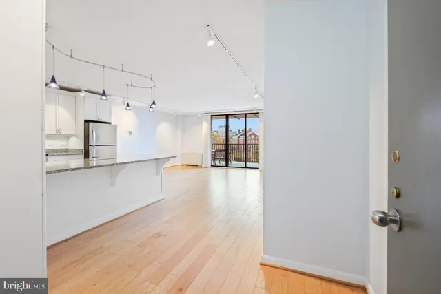 a view of a kitchen with wooden floor and a window