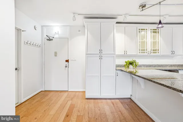 a bathroom with a granite countertop sink a toilet and shower