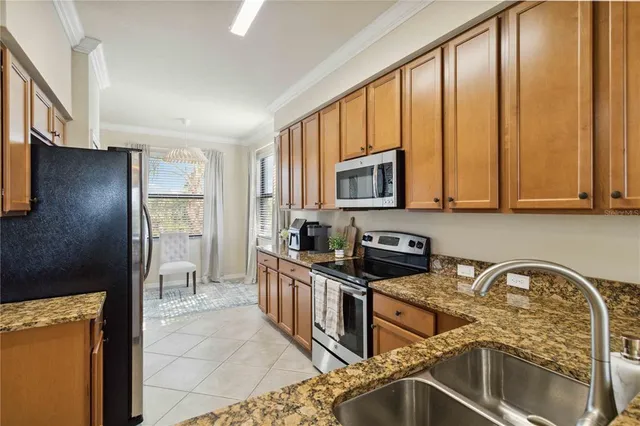 a kitchen with granite countertop a refrigerator and a stove top oven
