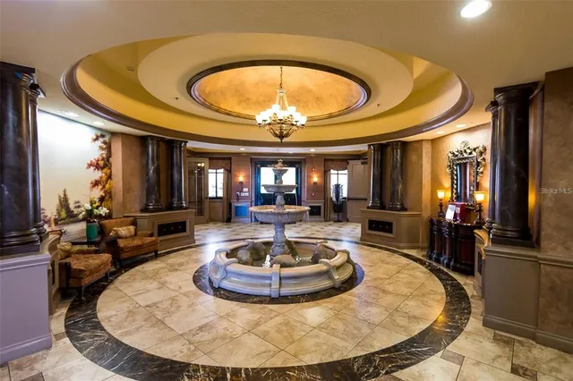 a room with lots of chairs a chandelier and a projector screen