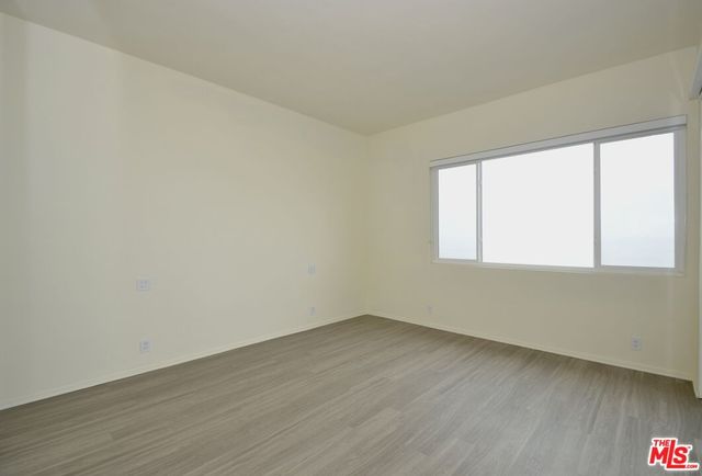an empty room with wooden floor and door