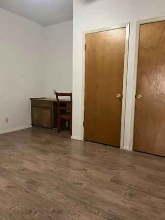 a view of a room with wooden floor and a bathroom