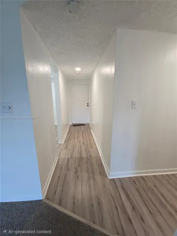 a view of a room with wooden floor and a sink