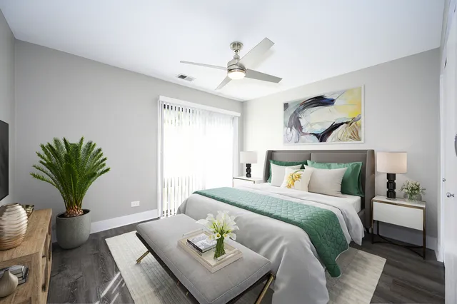 a bedroom with a bed a couch and a potted plant