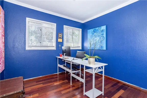 a view of a workspace with furniture and wooden floor