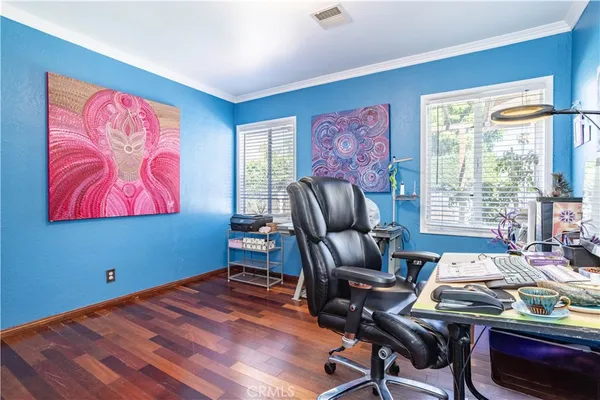 a bedroom with a bed and a painting on the wall