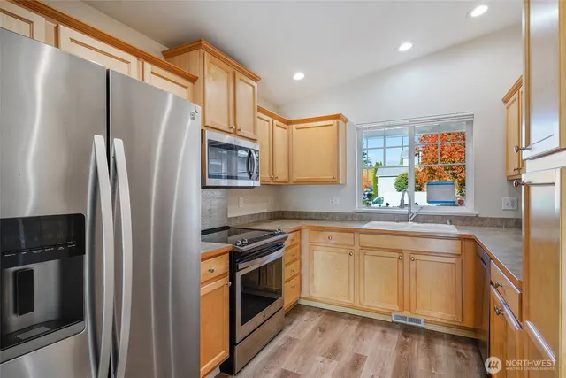 a kitchen with stainless steel appliances a refrigerator sink and microwave