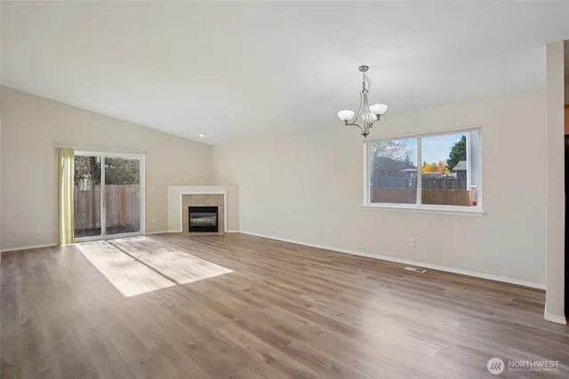 a view of an empty room with a window and fireplace