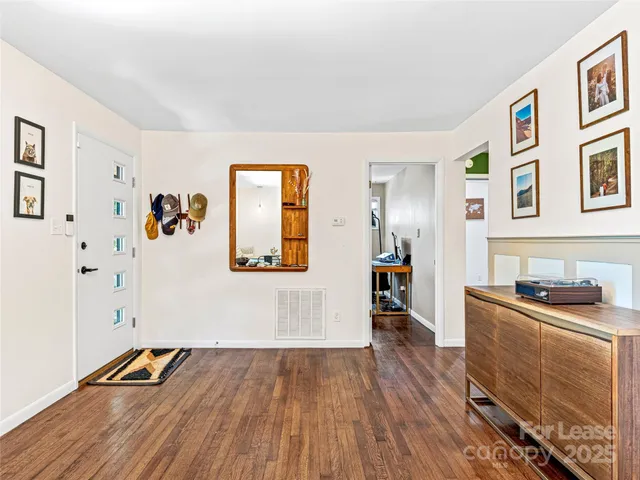 a dining room with furniture a window and wooden floor