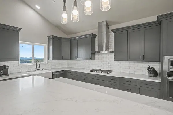 a kitchen with stainless steel appliances granite countertop a sink stove and refrigerator