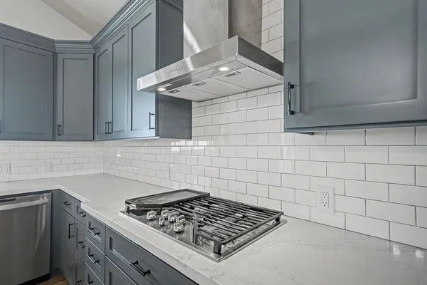 a kitchen with stainless steel appliances granite countertop a sink dishwasher a stove and a microwave oven with cabinets