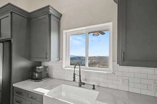 a kitchen with stainless steel appliances granite countertop a sink dishwasher a stove and a refrigerator with wooden cabinets