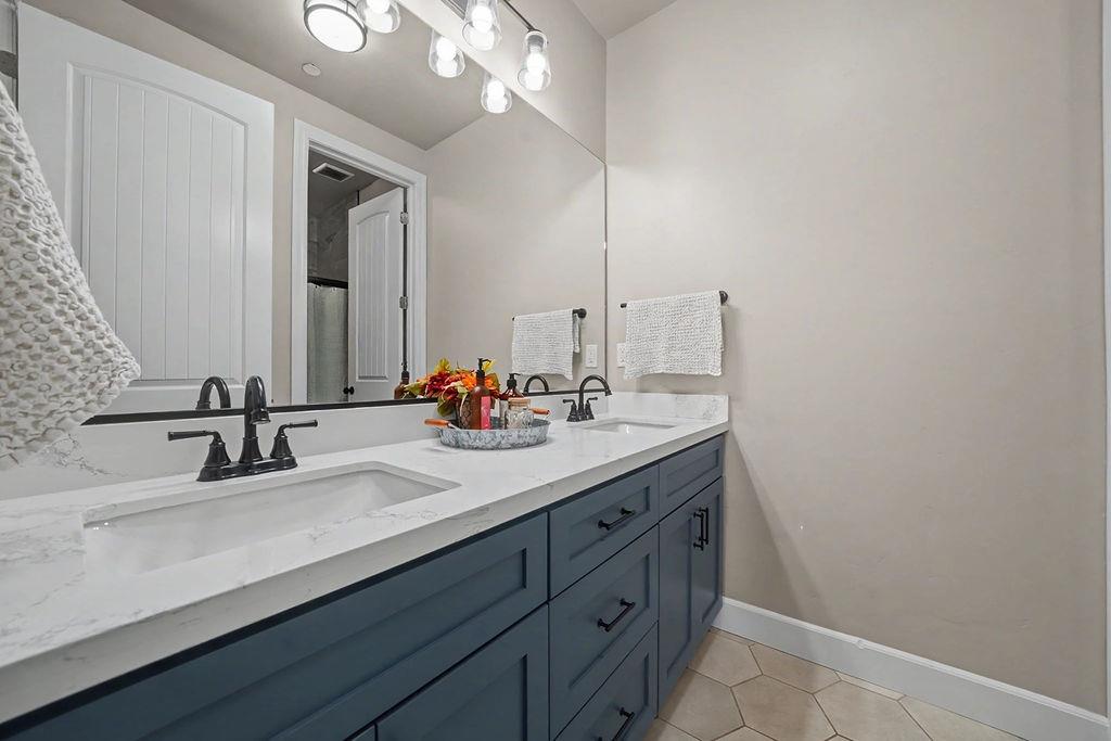 9515 Ham Luddy Road Mountain Ranch, CA 95246 - Photo 36 of 92 a bathroom with double vanity sink and a mirror