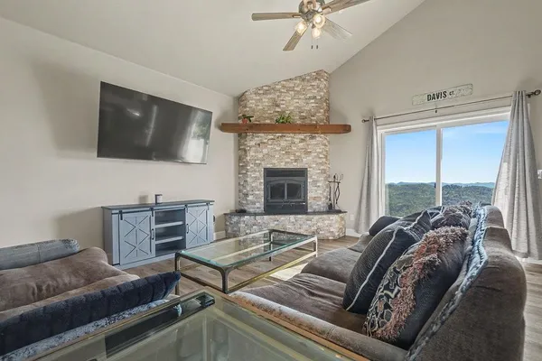 a living room with furniture large windows and a fireplace