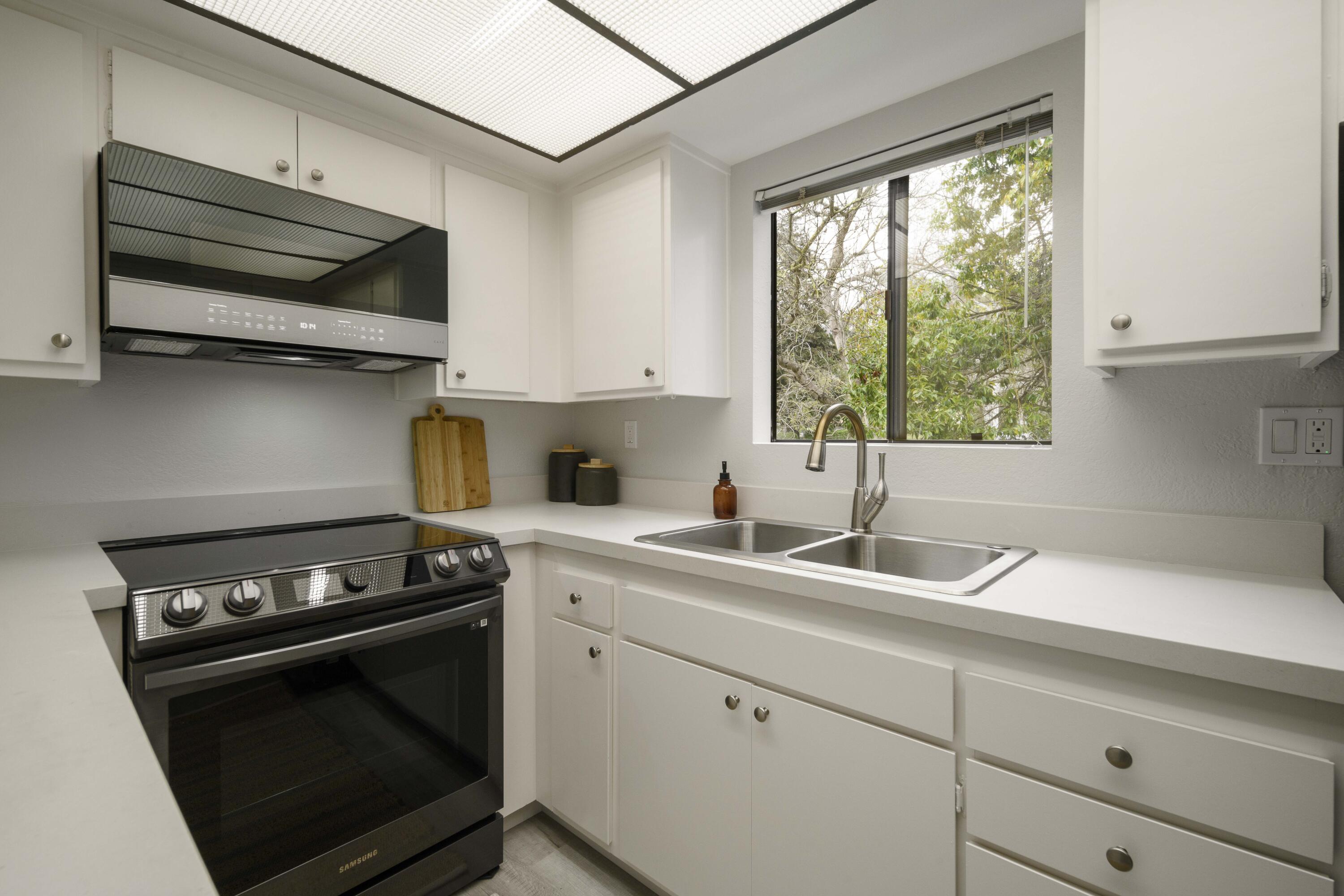 3375 Foothill Road, Unit 1121 Carpinteria, CA 93013 - Photo 8 of 24 a kitchen with stainless steel appliances white cabinets and a stove top oven