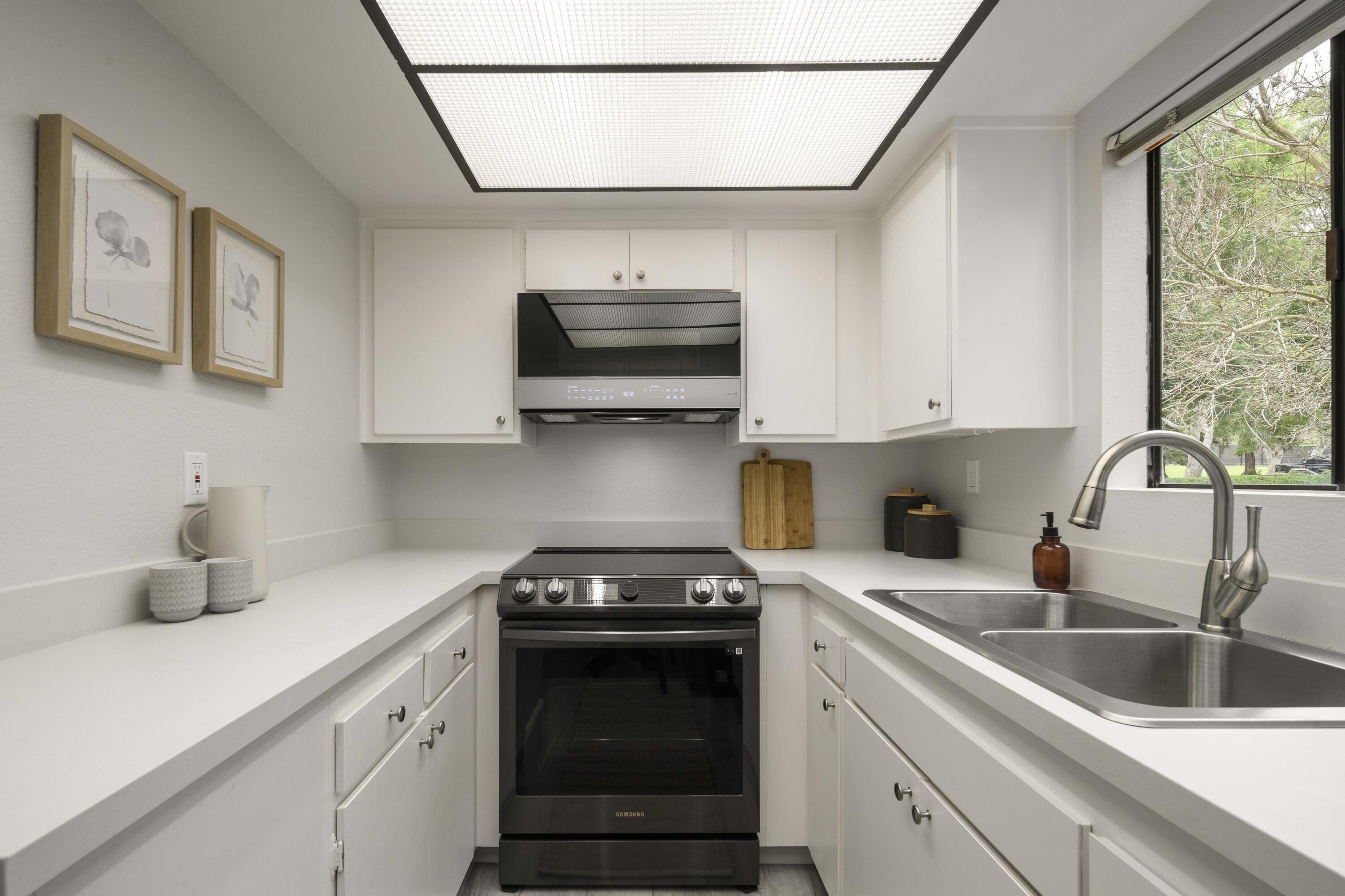3375 Foothill Road, Unit 1121 Carpinteria, CA 93013 - Photo 10 of 24 a kitchen with stainless steel appliances a sink a stove a microwave a refrigerator and cabinets