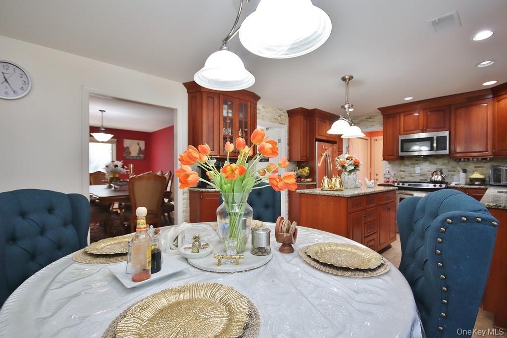 7 Park Place Chester, NY 10918 - Photo 11 of 48 a kitchen with stainless steel appliances granite countertop a stove a sink a dining table and chairs