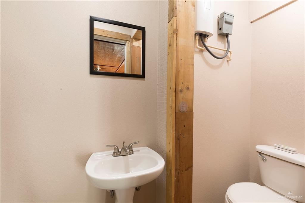 508 Patricia Street Mission, TX 78572 - Photo 13 of 24 Pedestal sink with chrome faucet, framed mirror, and toilet