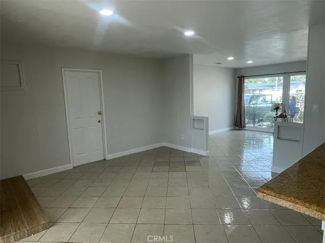 an empty room with wooden floor and natural light