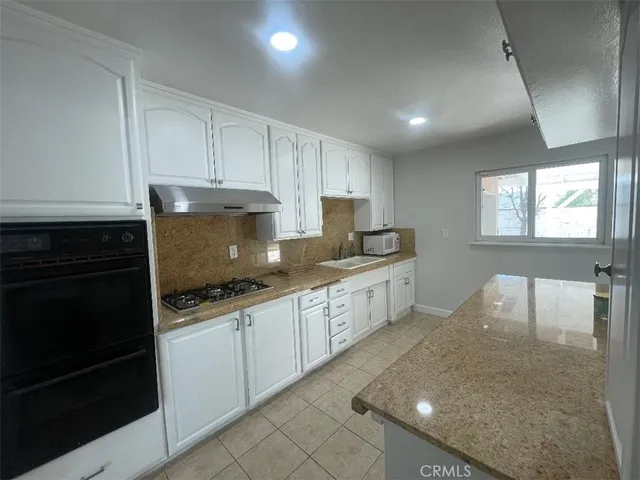 a large kitchen with a stove top oven a sink dishwasher and a refrigerator