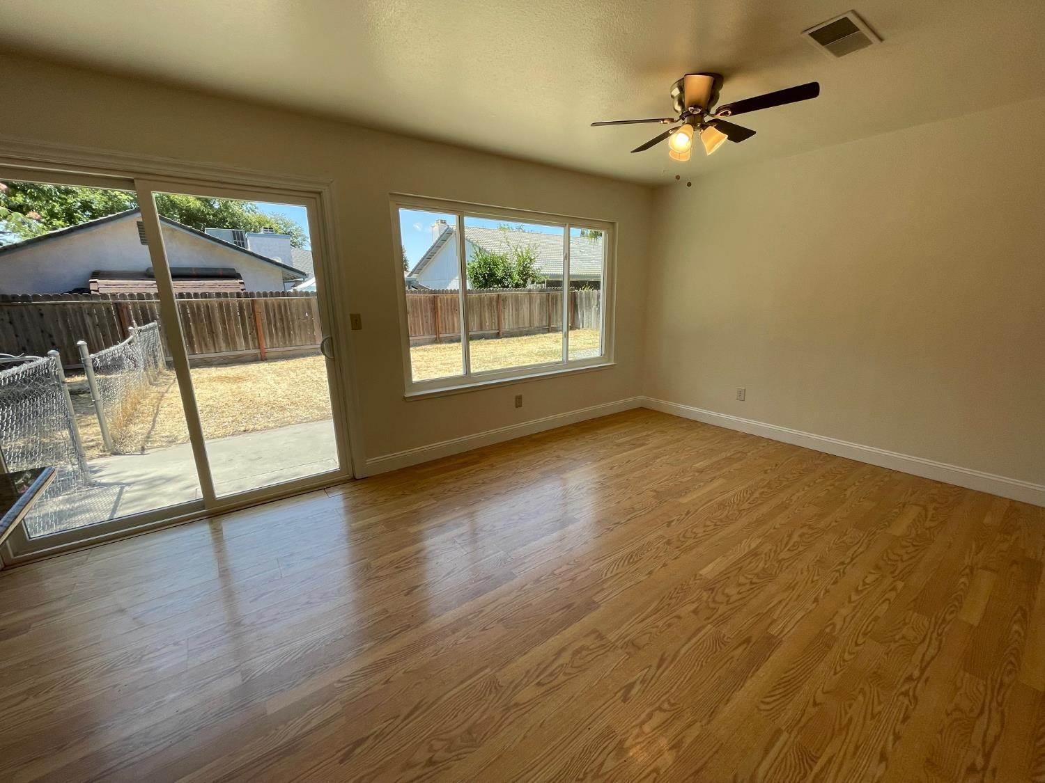 3101 Wyatt Way Modesto, CA 95350 - Photo 7 of 17 an empty room with wooden floor and windows