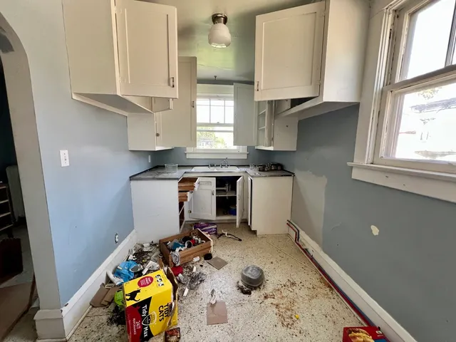 a room with stainless steel appliances granite countertop a sink a stove and a window