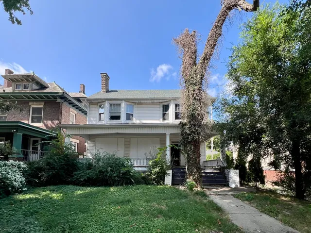 a front view of a house with a garden and plants
