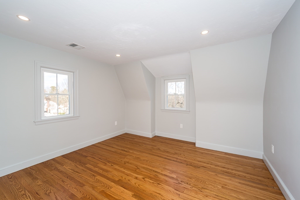 12 Bay State Road Natick, MA 01760 - Photo 23 of 35 a view of empty room with wooden floor and fan