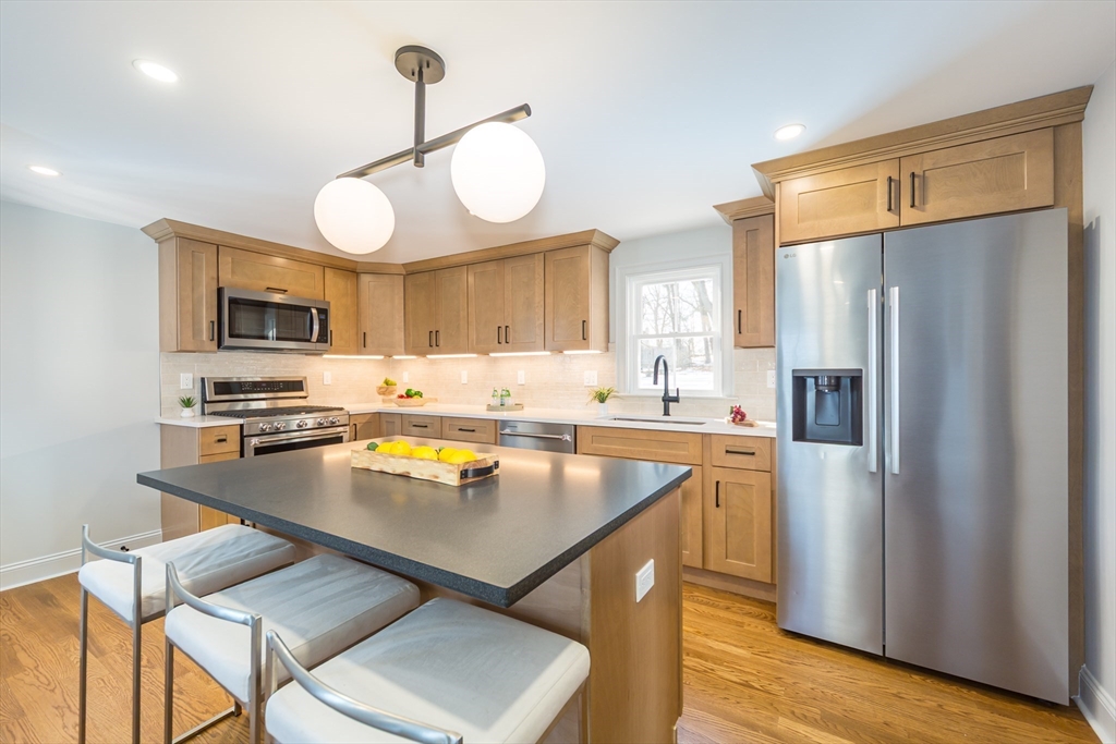 12 Bay State Road Natick, MA 01760 - Photo 10 of 35 a kitchen with stainless steel appliances granite countertop a refrigerator a sink dishwasher a stove and a refrigerator with wooden floor