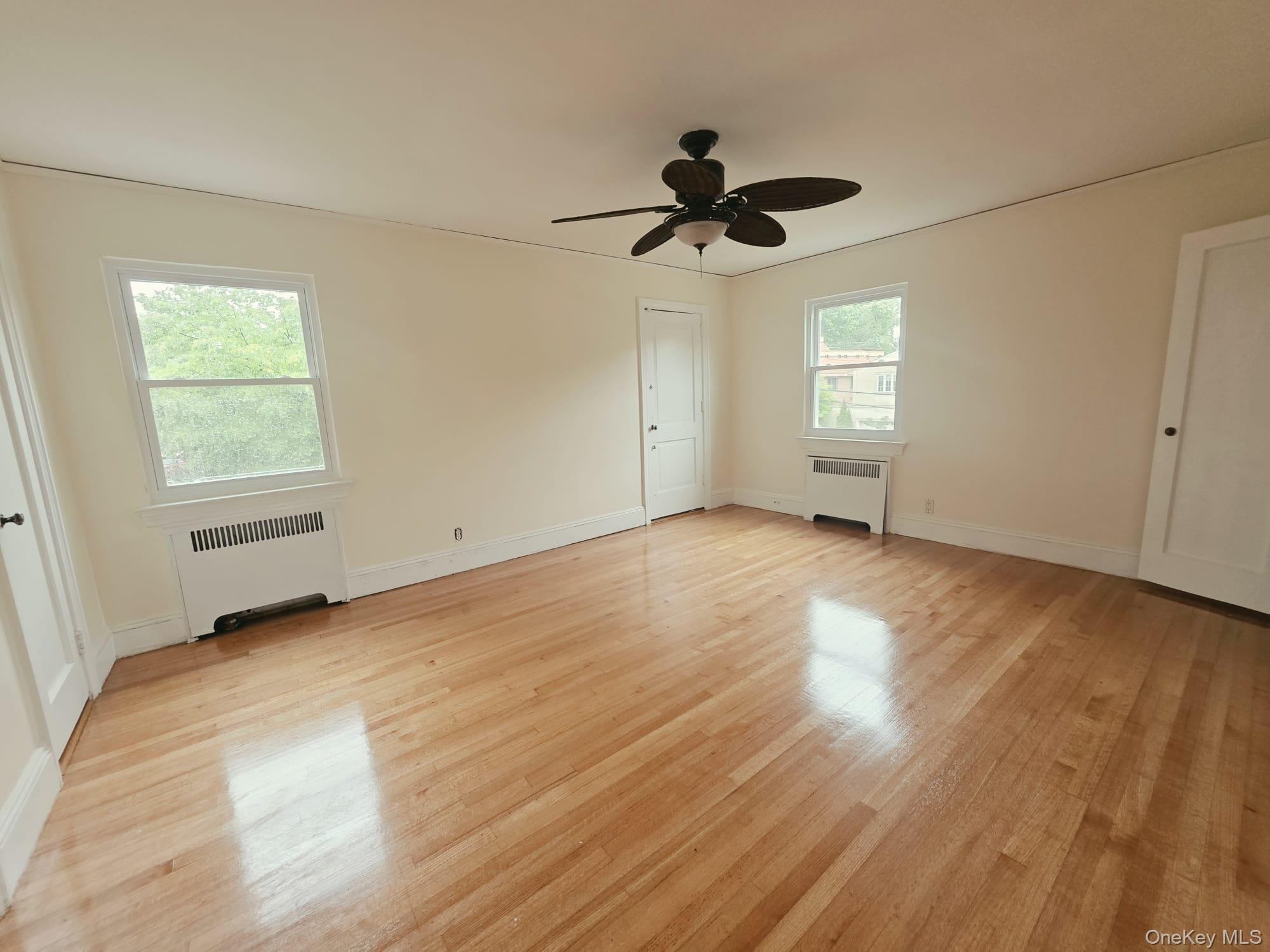 180-15 Dalny Road Queens, NY 11432 - Photo 9 of 10 wooden floor in an empty room with a window