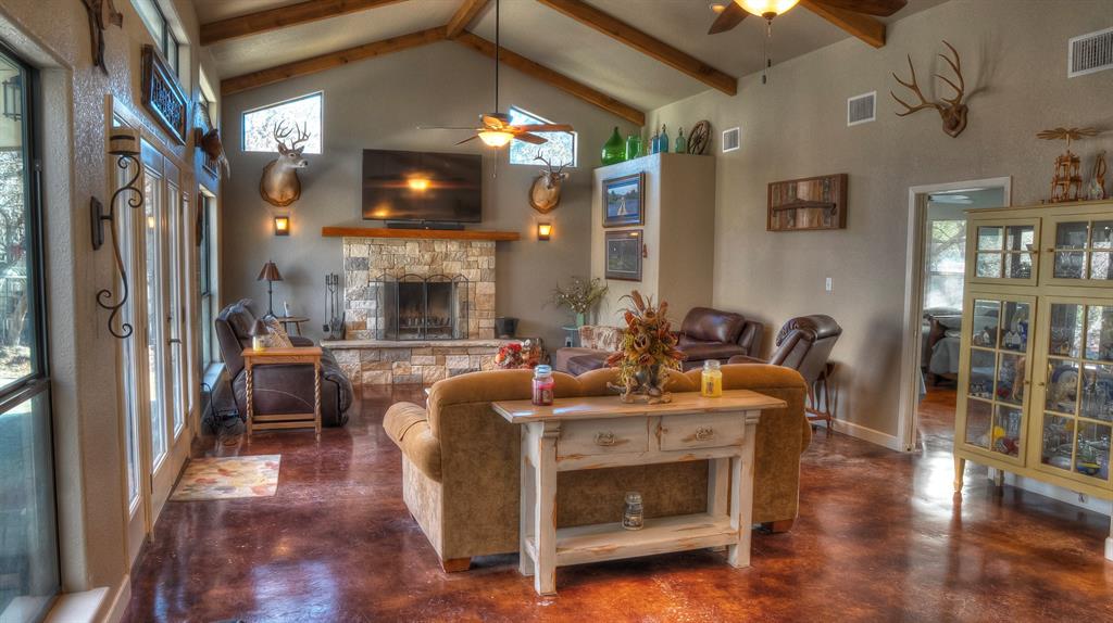 187 Roy Chisum Road Leakey, TX 78873 - Photo 10 of 40 a living room with furniture a fireplace and a flat screen tv