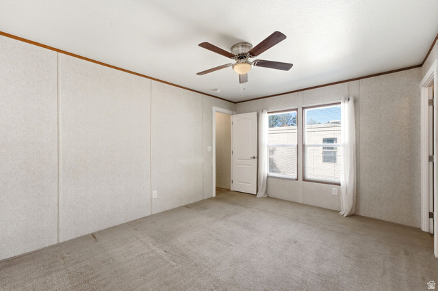 2875 North Hill Field Road, Unit 62 Layton, UT 84041 - Photo 18 of 34 Spacious room featuring neutral carpeting, light-toned wall paneling, and a ceiling fan with integrated lighting