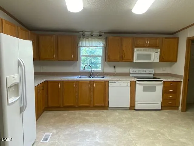 a kitchen with stainless steel appliances granite countertop a stove a sink and a refrigerator