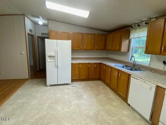 a kitchen with granite countertop a refrigerator and a sink