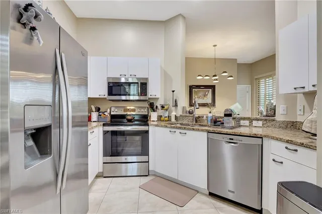 a kitchen with granite countertop a sink stainless steel appliances and cabinets