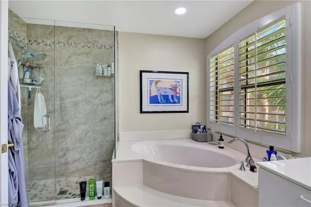 a white bath tub sitting next to a white sink and a shower