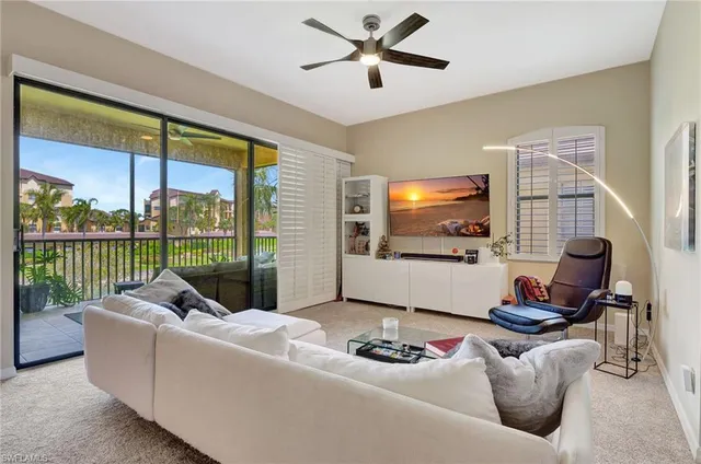 a living room with furniture tv and a floor to ceiling window