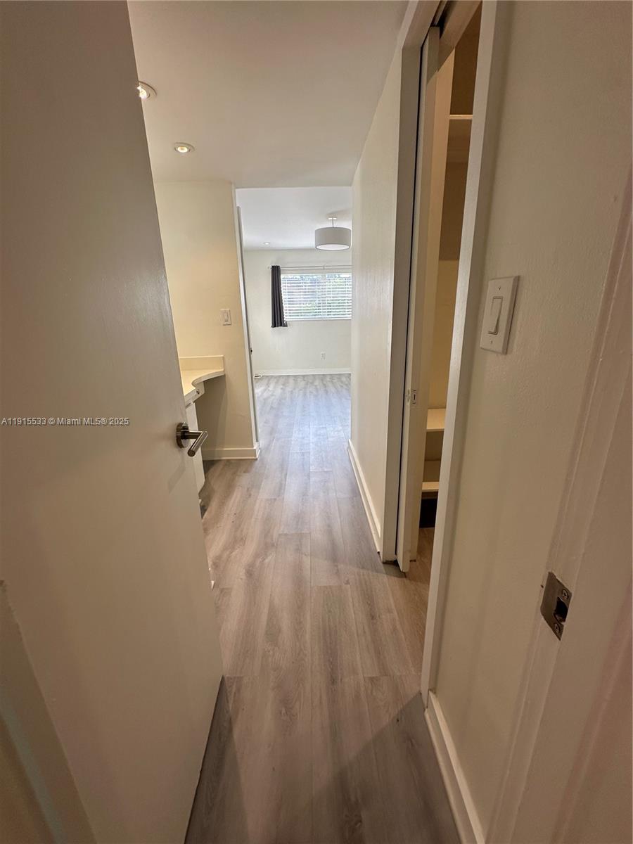 7505 Southwest 82nd Street, Unit 211 Miami, FL 33143 - Photo 11 of 17 a view of a hallway with wooden floor and staircase