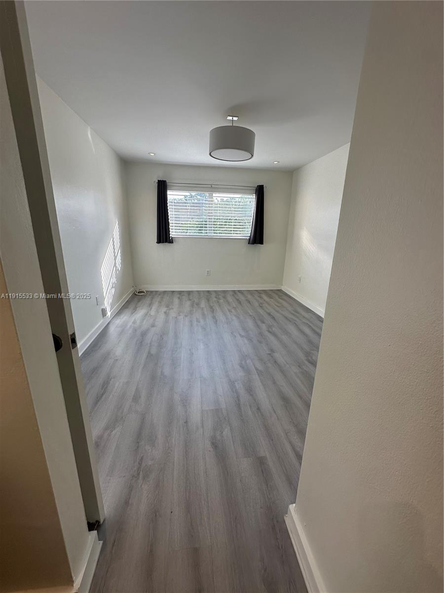 7505 Southwest 82nd Street, Unit 211 Miami, FL 33143 - Photo 12 of 17 wooden floor in an empty room with a window