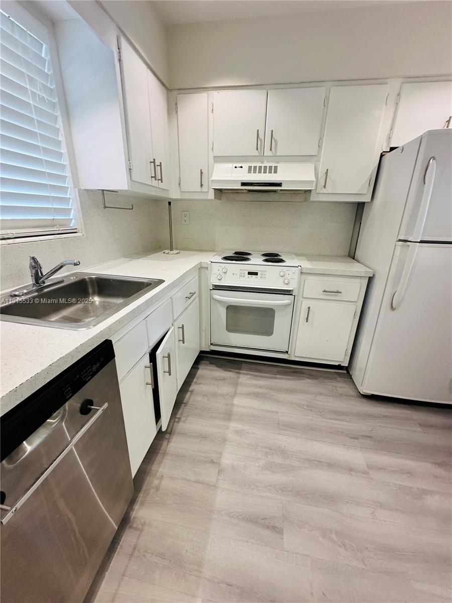 7505 Southwest 82nd Street, Unit 211 Miami, FL 33143 - Photo 6 of 17 a kitchen with a sink a stove and cabinets