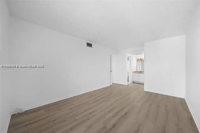 a view of a room with wooden floor and white walls