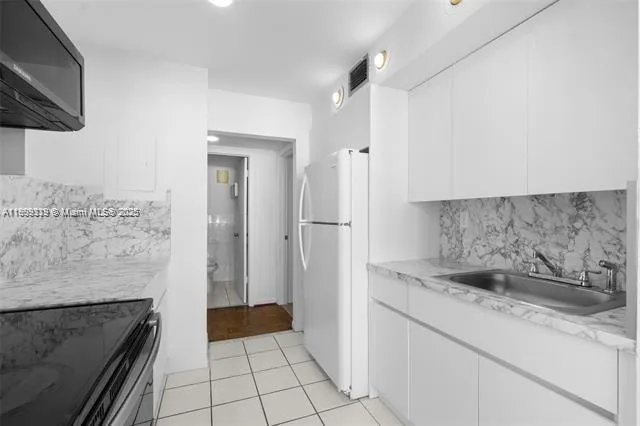 a kitchen with granite countertop a stove and a refrigerator