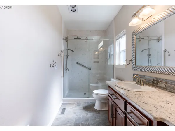 a bathroom with a granite countertop sink toilet and shower